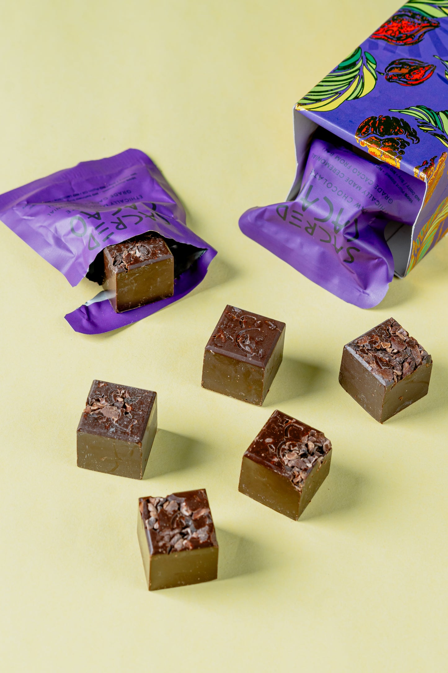 Open box of Sacred Cacao chocolates with packets and chocolates spilling out.