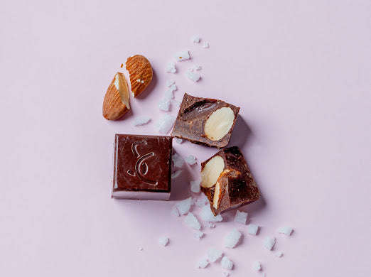 Almond and sea salt chocolate pieces surrounded by salt and almonds.